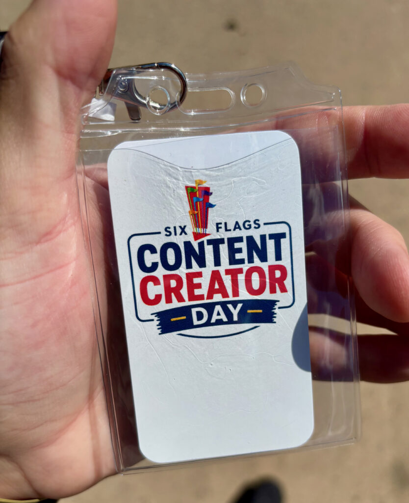 A hand holding a tag that says "Six Flags Content Creator Day" for Six Flags Great Adventure review. 
