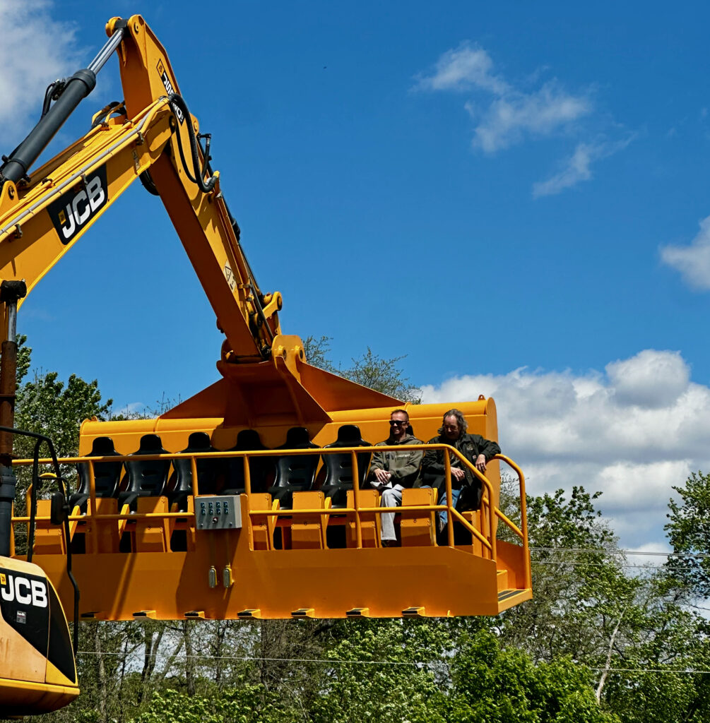 Diggerland USA Review photo showing 2 riders in a modified excavator bucket that has seats for riding in. 