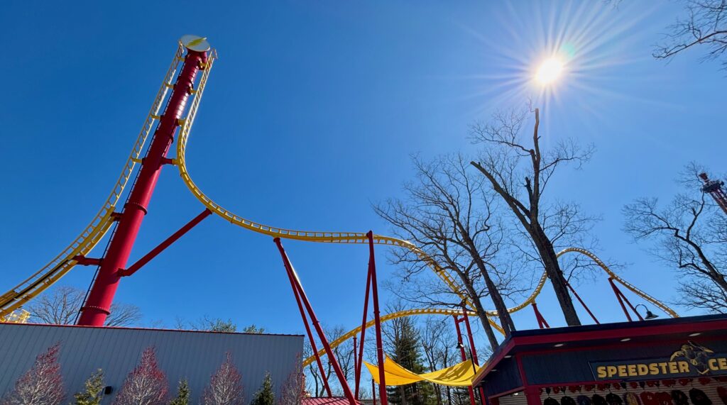 A yellow roller coaster with bright blue sky behind it and red supports for a Six Flags Great Adventure review
