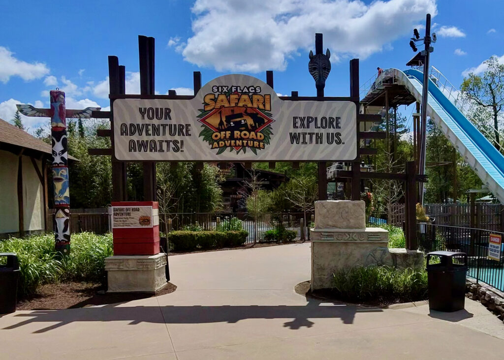 A sign that says "Your adventure awaits! Six Flags Safari Off Road Adventure. Explore with us." for a Six Flags Great Adventure review