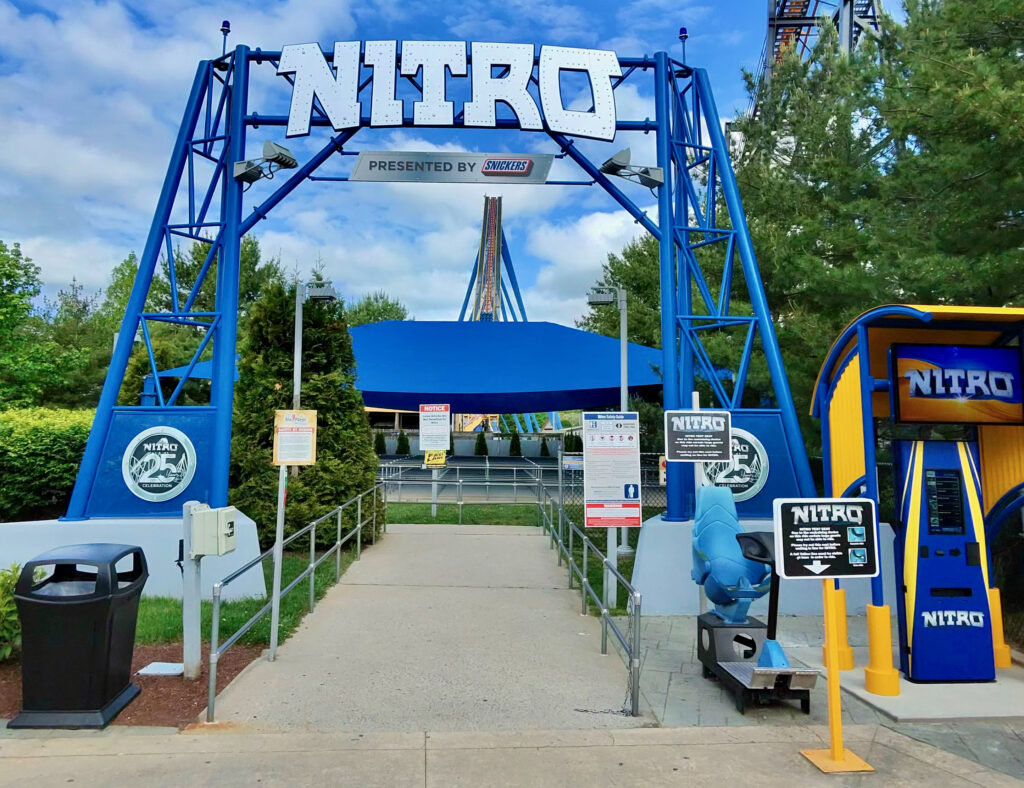 Six Flags Great Adventure review photo of the Nitro entrance sign with the coaster’s lift hill visible in the background.