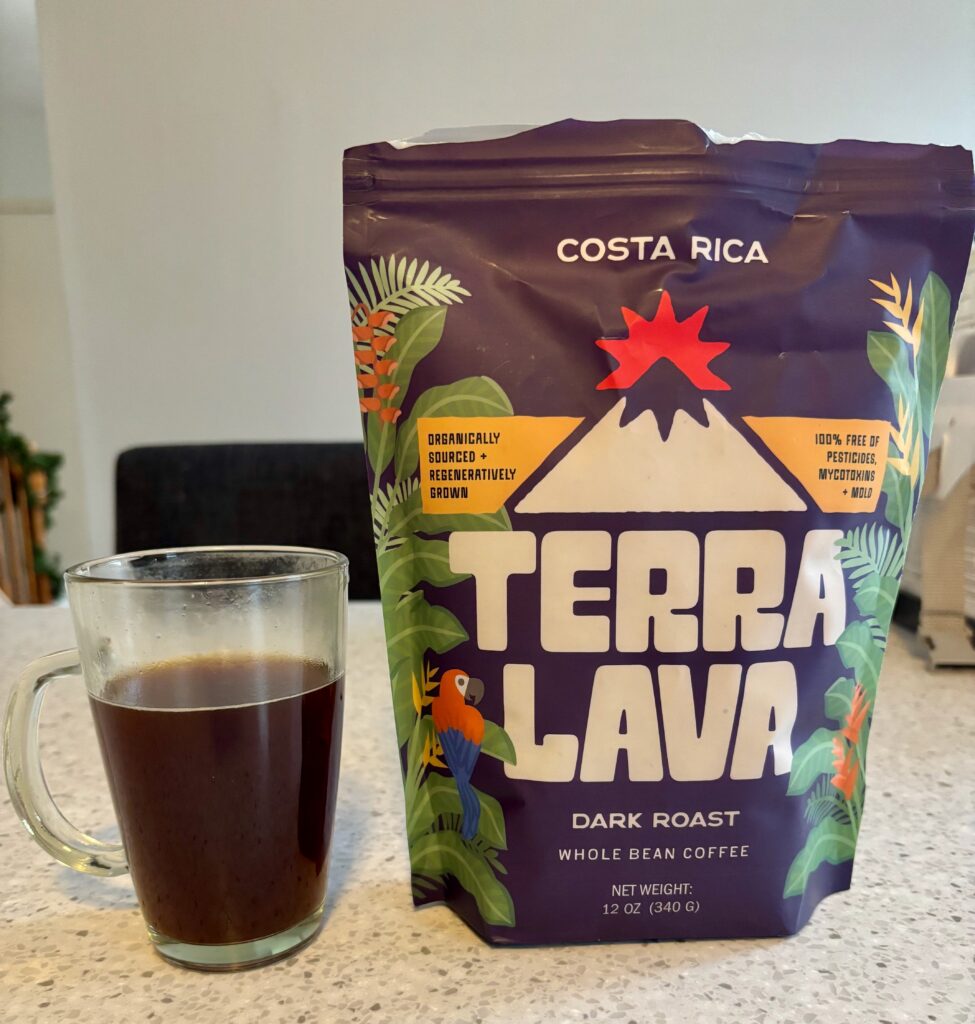 Terra Lava Costa Rican Dark Roast coffee review showing purple coffee bag with parrot design and brewed black coffee, one of the best dark roast coffees